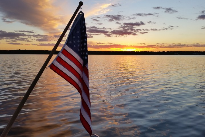 american flag in foreground, sunset in background