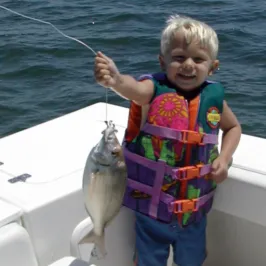 little boy holding up a fish