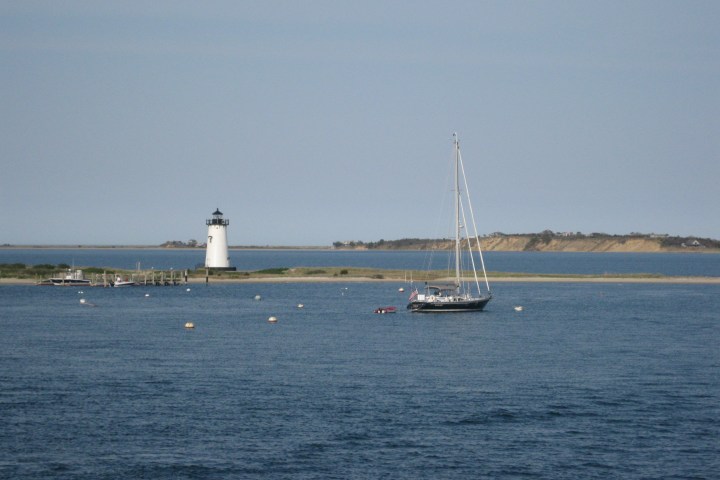 lighthouse with water infront and behind