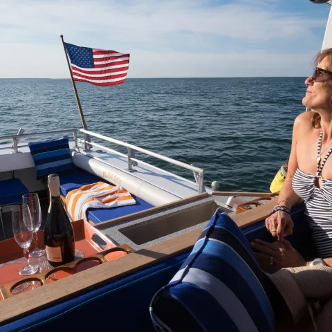 woman on back of boat with champagne