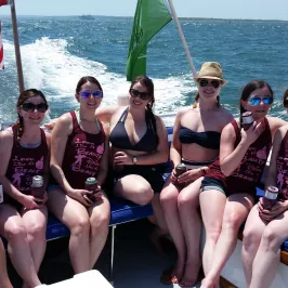 group of girls sitting on the back of the boat