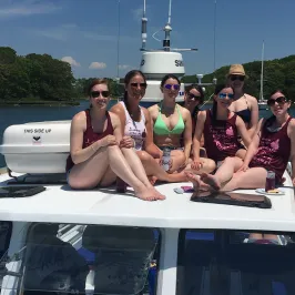 group of girls sitting on top of the boat