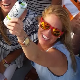 a girl raising her drink up and smiling