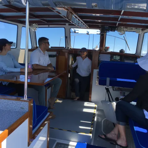 Passengers enjoy the boat ride and each other's company inside the luxurious pilothouse